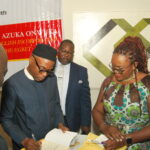 Azuka autographing books